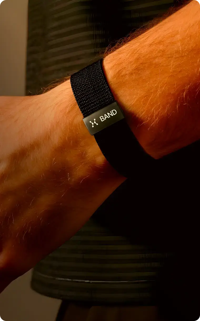 Close-up of a person wearing a Hume Band on wrist with text promoting longevity tracking, aging prevention, and powerful health data insights.